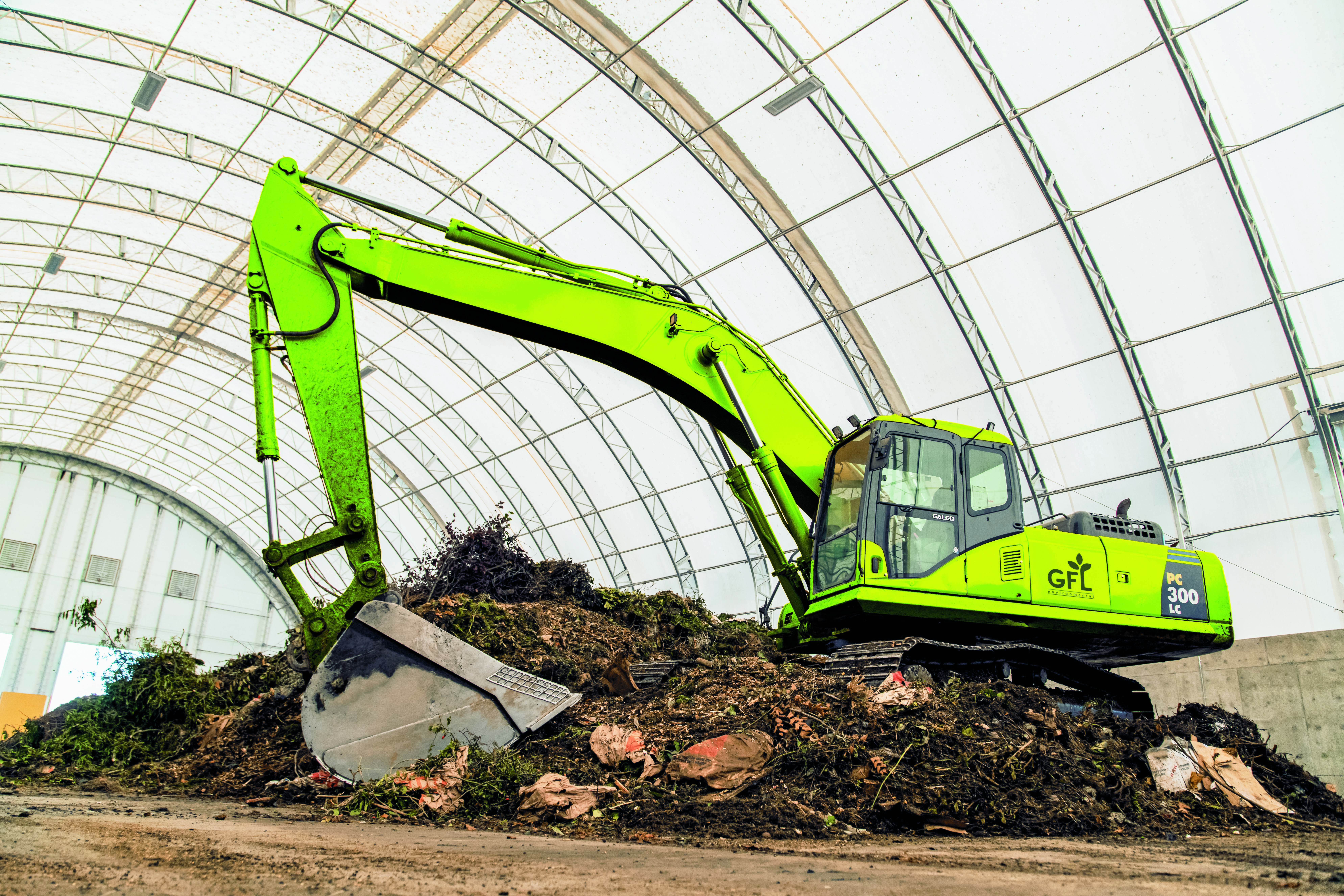 Excavator pulls trash from a site. This is a GFL excavator.